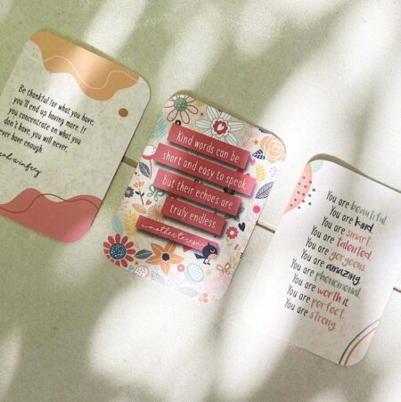 Kindness cards in palm shadow